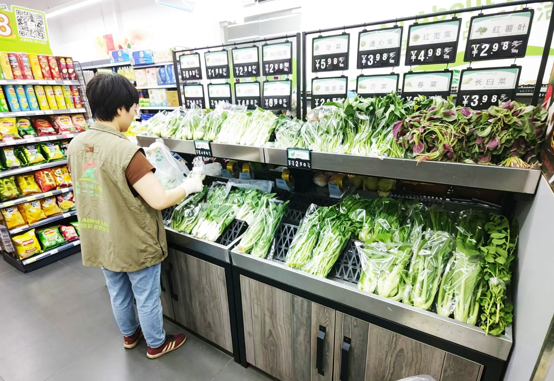 在西丽街道松坪山社区,居民楼下的新一佳生活超市员工分拣当日未售完新鲜蔬菜,送给社区困难家庭。吴可 摄.jpg