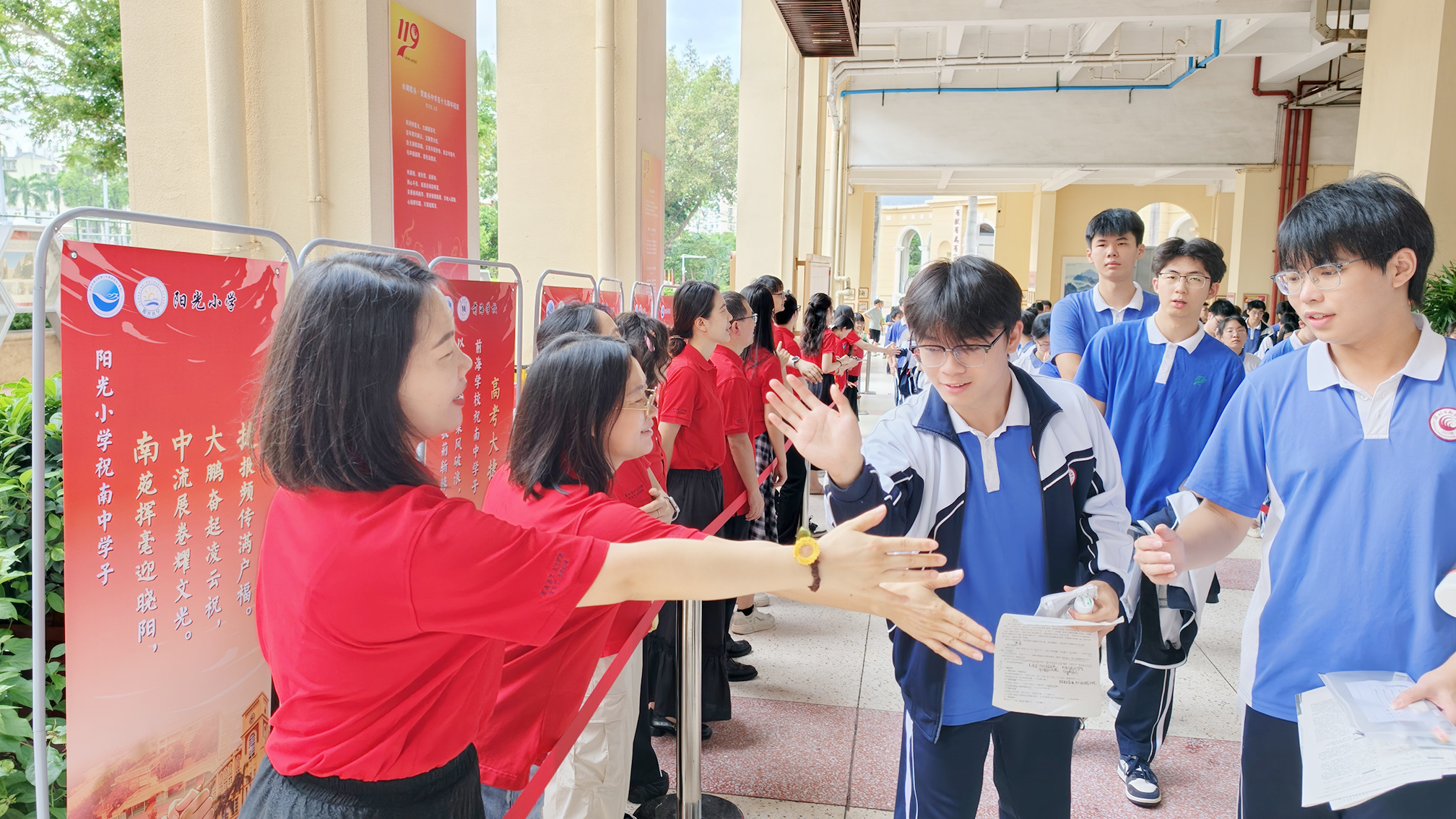 南头中学教师与考生击掌，为其加油鼓劲。学校供图.jpg